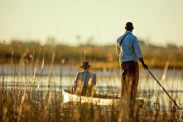 Men on a small boat - Okavango - Botswana